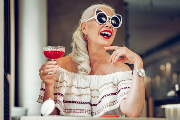 Радостная милая женщина наслаждается своим модным коктейлем — стоковое фото