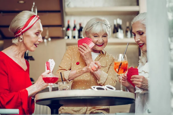 Счастливые милые пожилые женщины, держащие свои карточки — стоковое фото