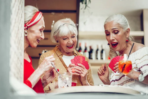 Mulheres idosas agradáveis felizes jogando cartas juntas — Fotografia de Stock