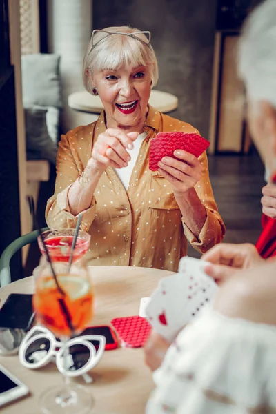 Alegre mujer feliz sentada con cartas en la mano — Foto de Stock