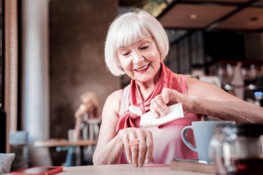 Bob saç kesimi sıkma el kremi ile Gülümseyen yaşlı kadın