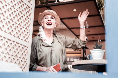 Hasır şapkalı neşeli güzel yaşlı kadın yakın arkadaşıyla buluşuyor