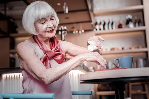 Блеск красивой пожилой женщины, отдыхающей в кафе и угощающей — стоковое фото
