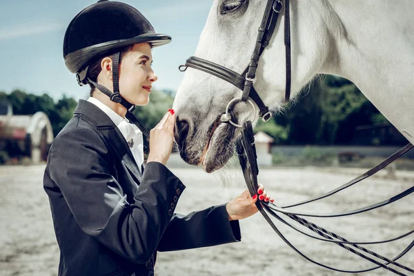 Agradable joven mujer tocando su nariz de caballo — Foto de Stock