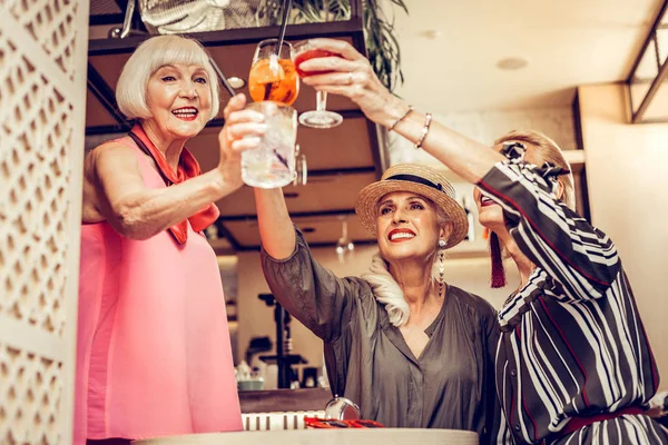 Сияющие элегантные старушки, звенящие стаканами с коктейлями — стоковое фото