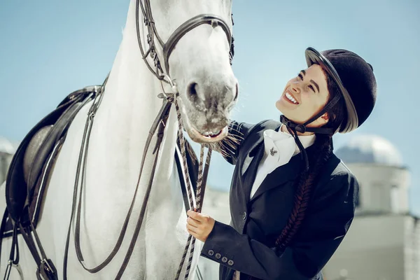 Encantada mujer feliz sonriendo a su caballo — Foto de Stock