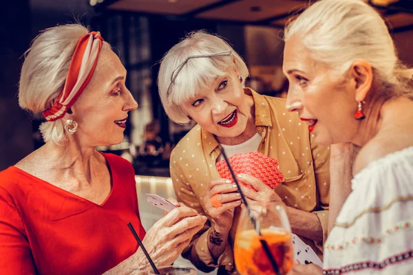 Tilltalande korthårig kvinna gömmer sina kort från blickar — Stockfoto