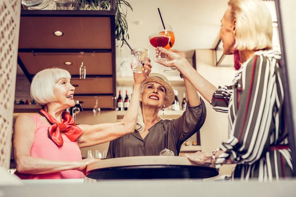 Веселые, ухоженные старушки, счастливо звенящие стаканы — стоковое фото