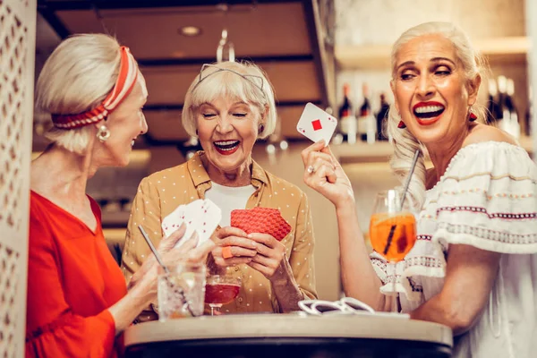 Смеющиеся, ухоженные пожилые женщины с карточками. — стоковое фото