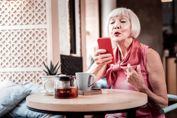 Gri saçlı yaşlı kadın parlak makyaj giyen ipek pembe bluz — Stok fotoğraf