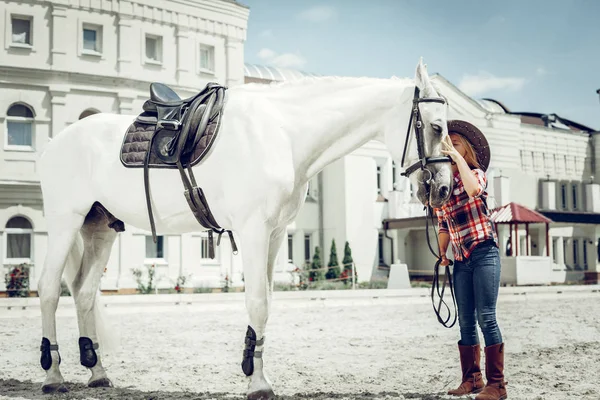 Przyjemny ładny dziewczyna stojący w pobliżu jej biały koń — Zdjęcie stockowe