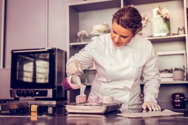 Özenli genç fırıncı kek üzerine tepesi aşağı dökülüyor