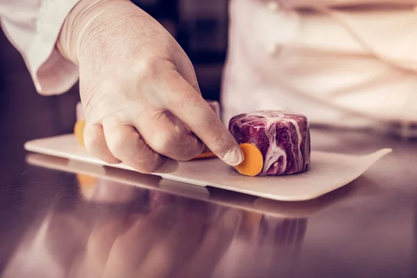 Fotografía enfocada en las manos que ponen decoración en los pasteles — Foto de Stock