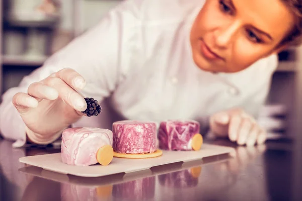 Närbild av glad Baker som stirrade på Berry — Stockfoto