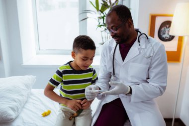 Komik çocuk oyuncak ile oynamak ve çocuk doktoru dinlerken