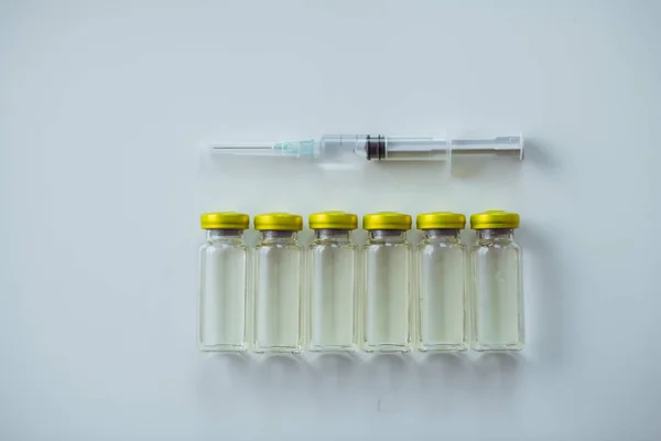 Strzykawka medyczna leżąca powyżej sześciu ampułek z antybiotykiem — Zdjęcie stockowe