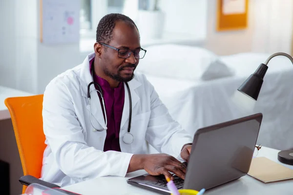 Bearded Dark-gevilde medische wetenschapper aan het werk op de laptop — Stockfoto
