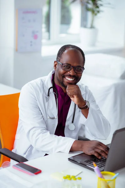 Vrolijke dokter glimlacht ruim na het maken van wetenschappelijke uitvinding — Stockfoto