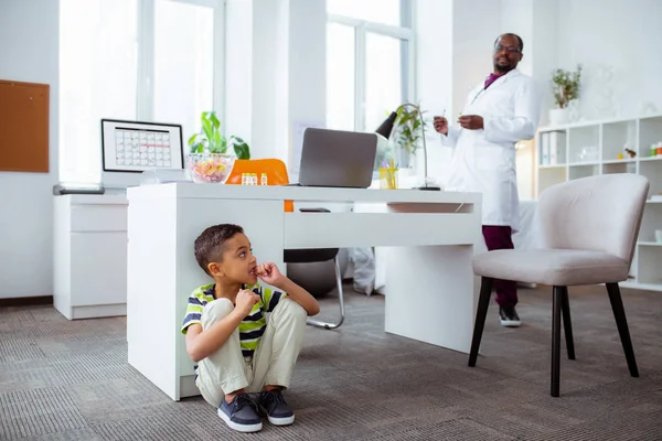 Schattige kleine jongen verbergen van vader werken in het ziekenhuis — Stockfoto