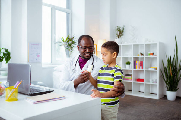 Отец работает врачом, давая своему миленькому сыну мороженое.
