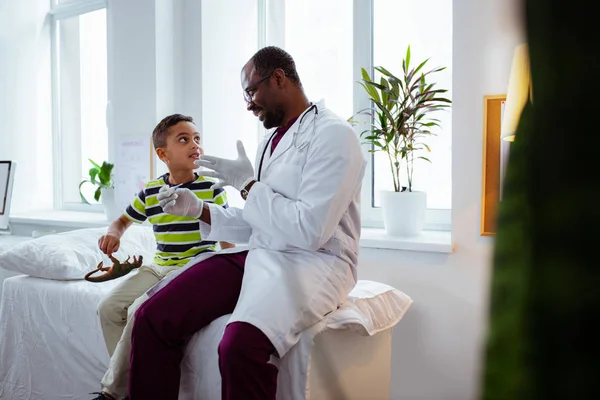 Kinderarzt spricht nach Temperaturmessung mit süßem Jungen — Stockfoto