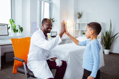 Sevimli çocuk hoş profesyonel çocuk doktoru için yüksek beş veren