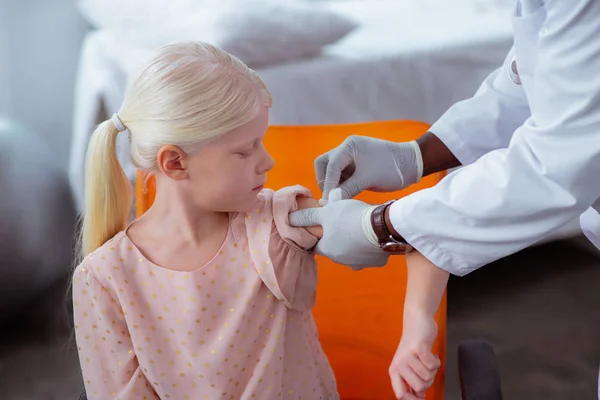 Doctor disinfecting skin after injection for cute girl — Stock Photo, Image