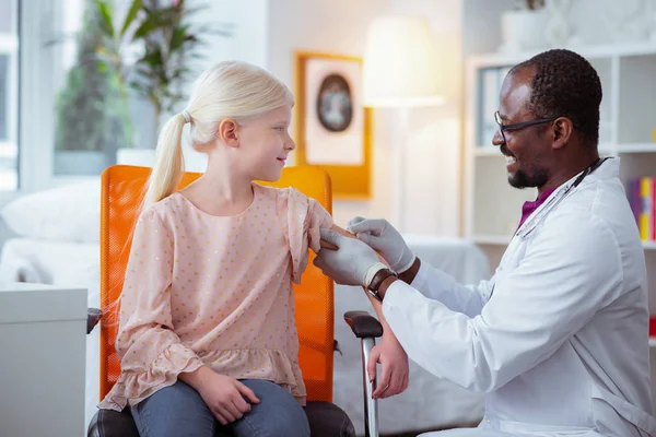 Kinderarts glimlachend tijdens het maken van injectie voor schoolmeisje — Stockfoto