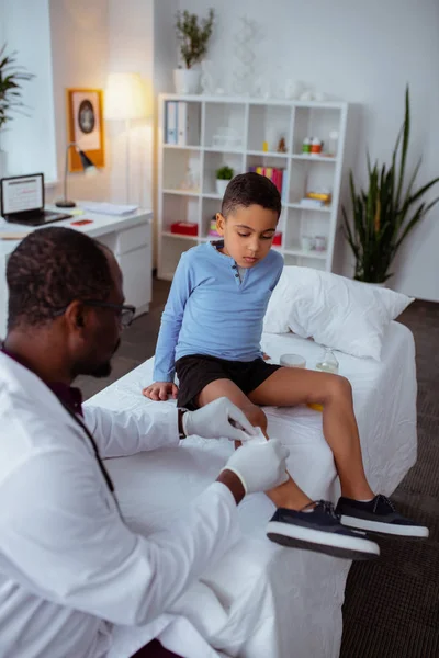 Stylish little boy visiting pediatrician after falling from bike — Stock Photo, Image