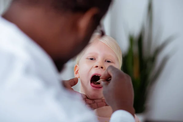 Primer plano de chica rubia abriendo la boca mientras viene al médico — Foto de Stock