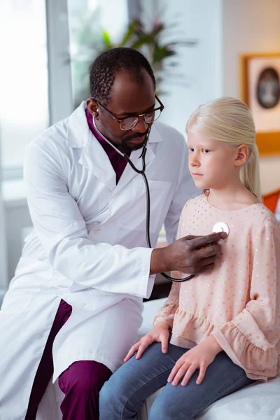 Médico usando estetoscopio mientras escucha los pulmones de la niña —  Fotos de Stock