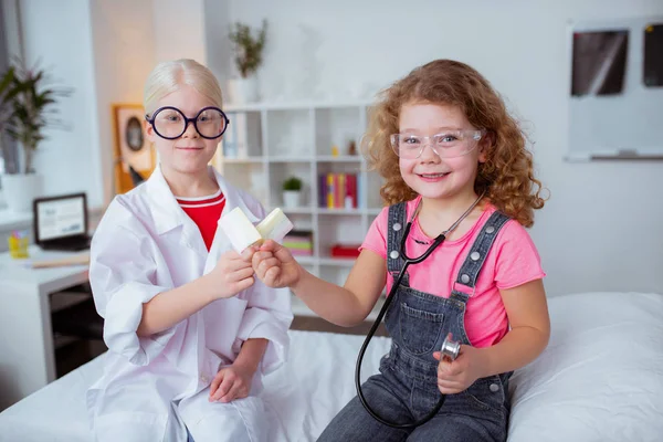 Curly girl eating ice cream with blonde friend wearing glasses — Stock Photo, Image