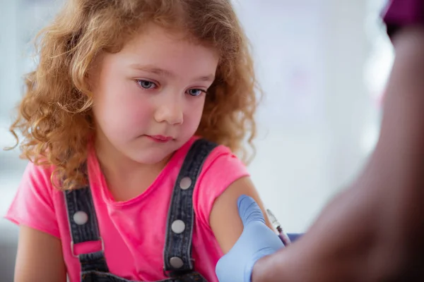 Blue-eyed curly girl having tears while getting injection — Stock Photo, Image