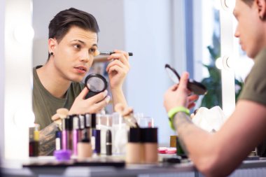 Pudra ile konteyner taşıyan özenli koyu saçlı adam