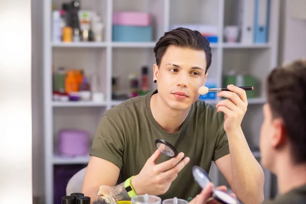 Krásný tmavovlasý mladík, který používá make-up — Stock fotografie