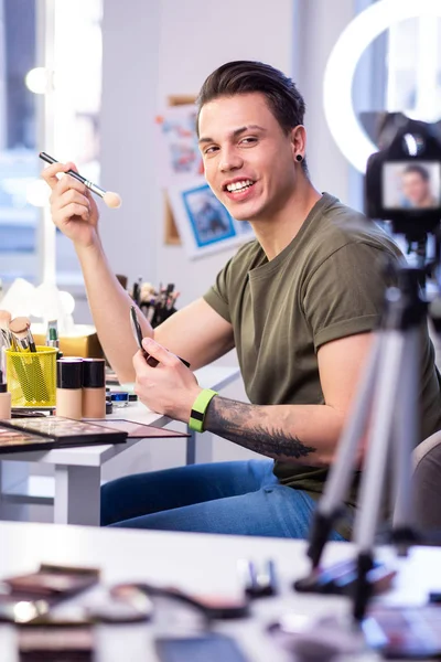 Aktivní kvalifikovaný člověk, který sedí u stolu krásy ve studiu — Stock fotografie