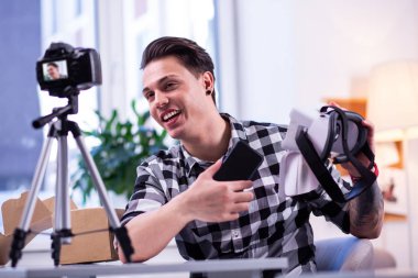 Damalı gömlek özellikleri açıklayan konuşkan iyi görünümlü adam