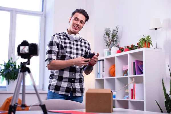 Active good-looking guy wearing checkered shirt and white headphones