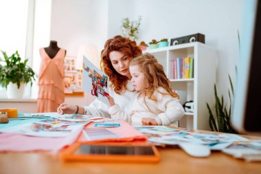 Mankenlerin fotoğraflarına bakan anneye yardım etmek le ilgili kız hissi