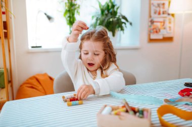 Kız anne atölyesinde iplikleri ile oynarken dahil duygu