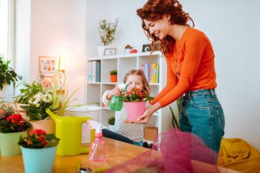 Kızıl saçlı anne kızı ile çiçek sulama mutlu hissediyorum