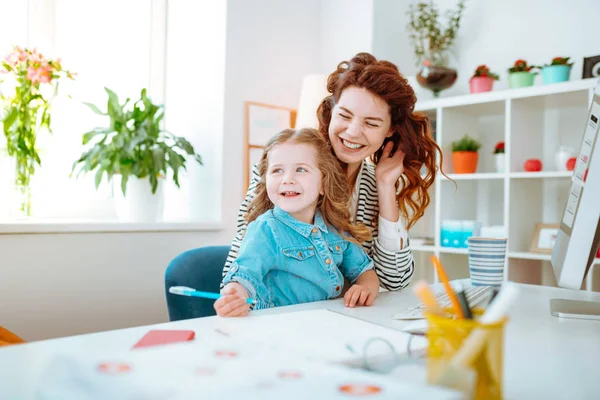 Teletrasporto madre ridere mentre seduto vicino al computer con la figlia — Foto Stock