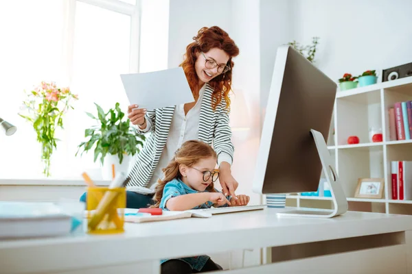 Mamma dai capelli rossi ridendo mentre insegna alla sua ragazza usando la tastiera — Foto Stock