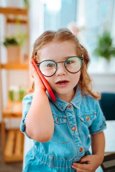 Hermosa linda chica con vestido de mezclilla y gafas llamando a su padre — Foto de Stock