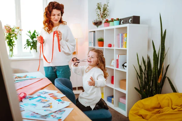 Menina segurando tesoura enquanto trabalhava no atelier com a mãe — Fotografia de Stock