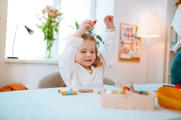 Meisje dragen trui spelen met threads een bezoek aan mam in atelier — Stockfoto