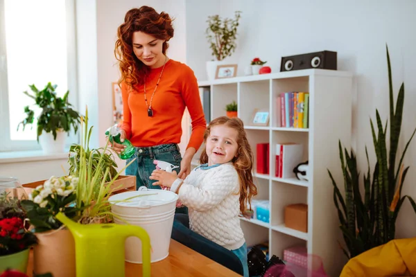 家庭用植物に水をまく拡散器を使用した母と娘 — ストック写真