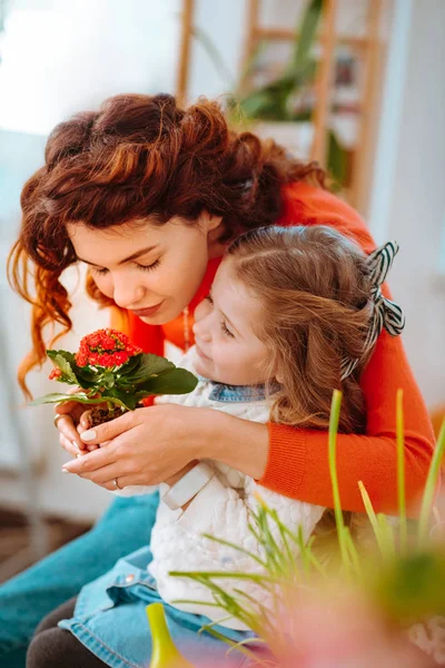 Roztomilá matka a dcera páchnoucí květiny společně — Stock fotografie
