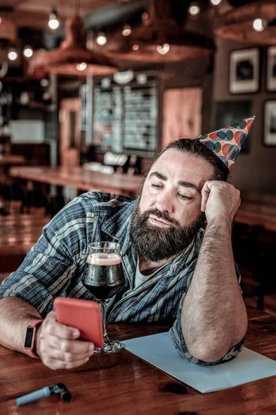 Bored birthday man reading a reply to his message.