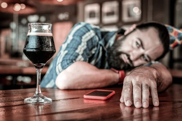 Celebrante di compleanno infelice sdraiato su un tavolo da pub . — Foto Stock